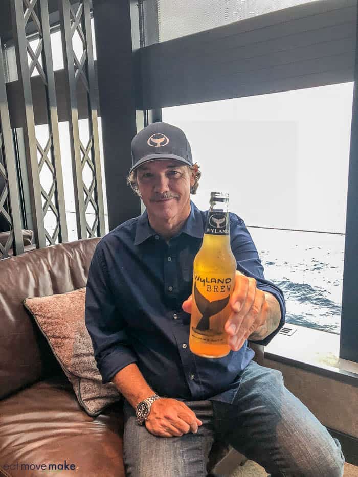 Robert Wyland sitting next to a glass of beer, with Norwegian Bliss and Water