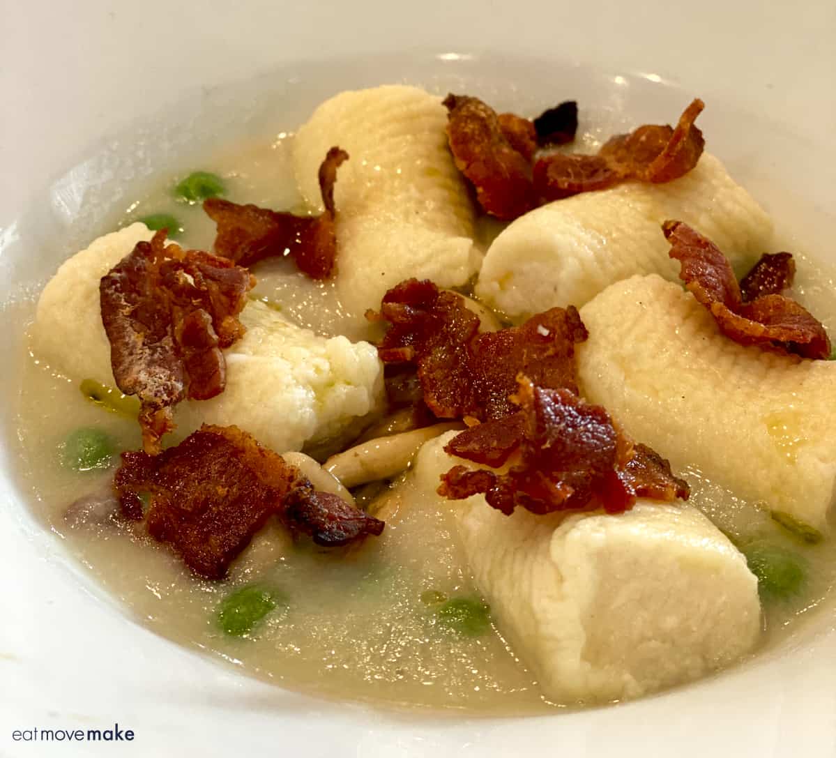 gnocchi with bacon on top in bowl