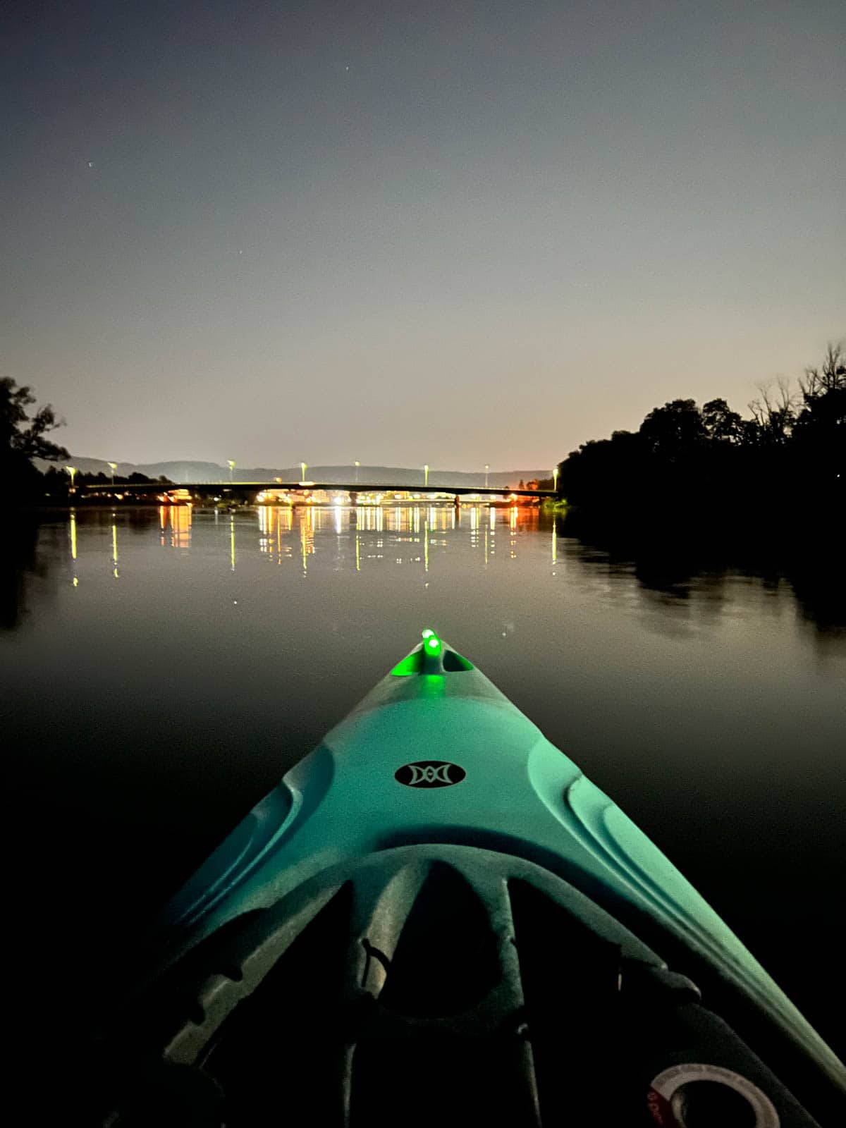 kayak with bridge in background at night