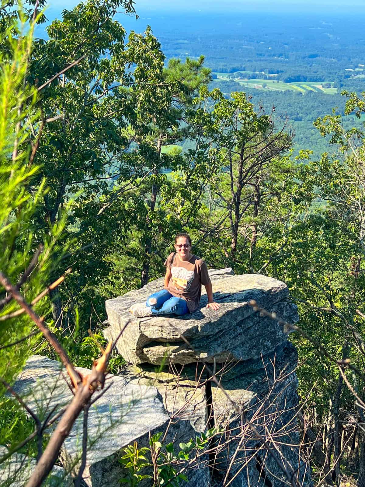 lady sitting on rock ledge at Pilot Mountain