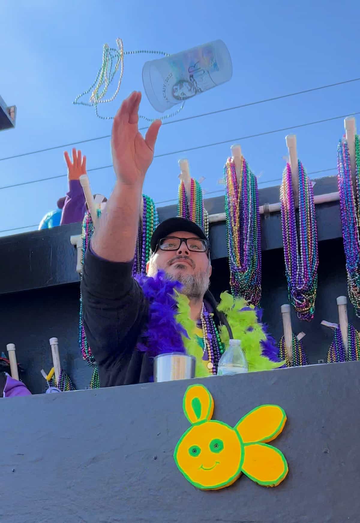 man throwing beads and cups