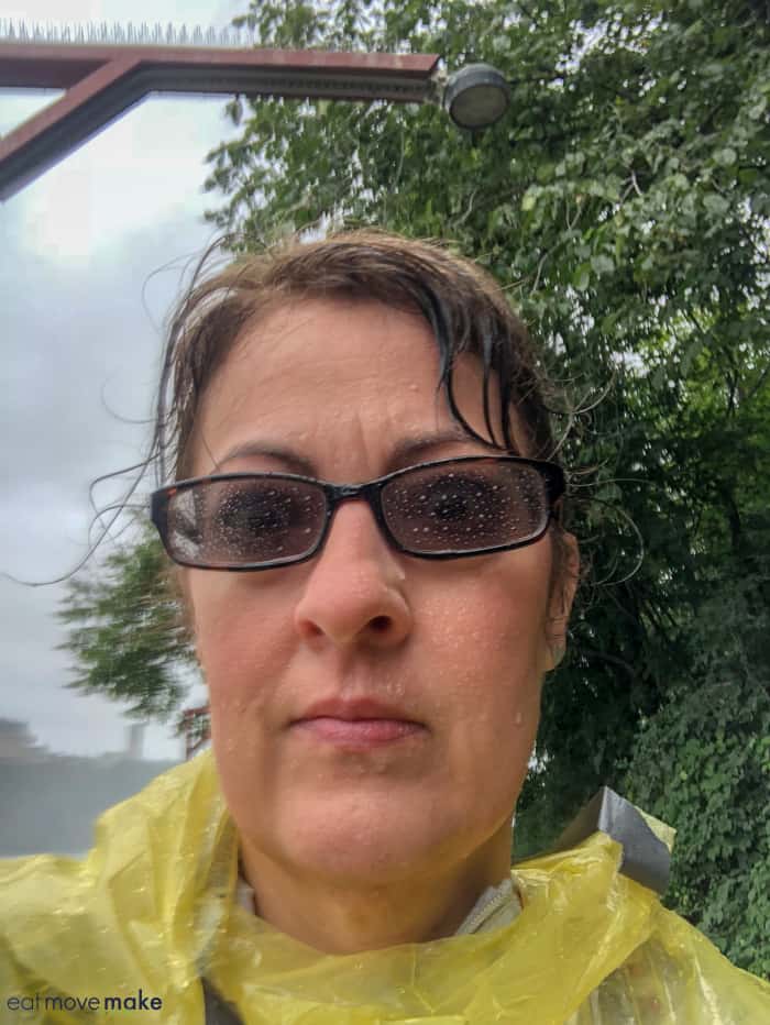 A person wearing sunglasses posing for the camera, with Niagara Falls