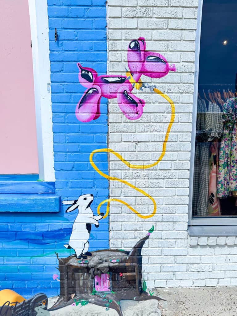 bunny and balloon mural on brick wall.