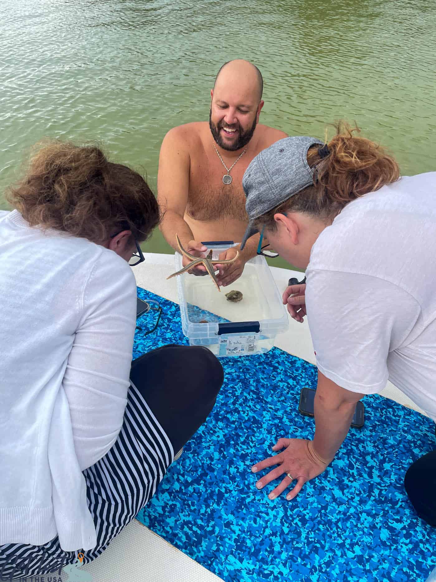 ladies studying sea creatures with tour guide.