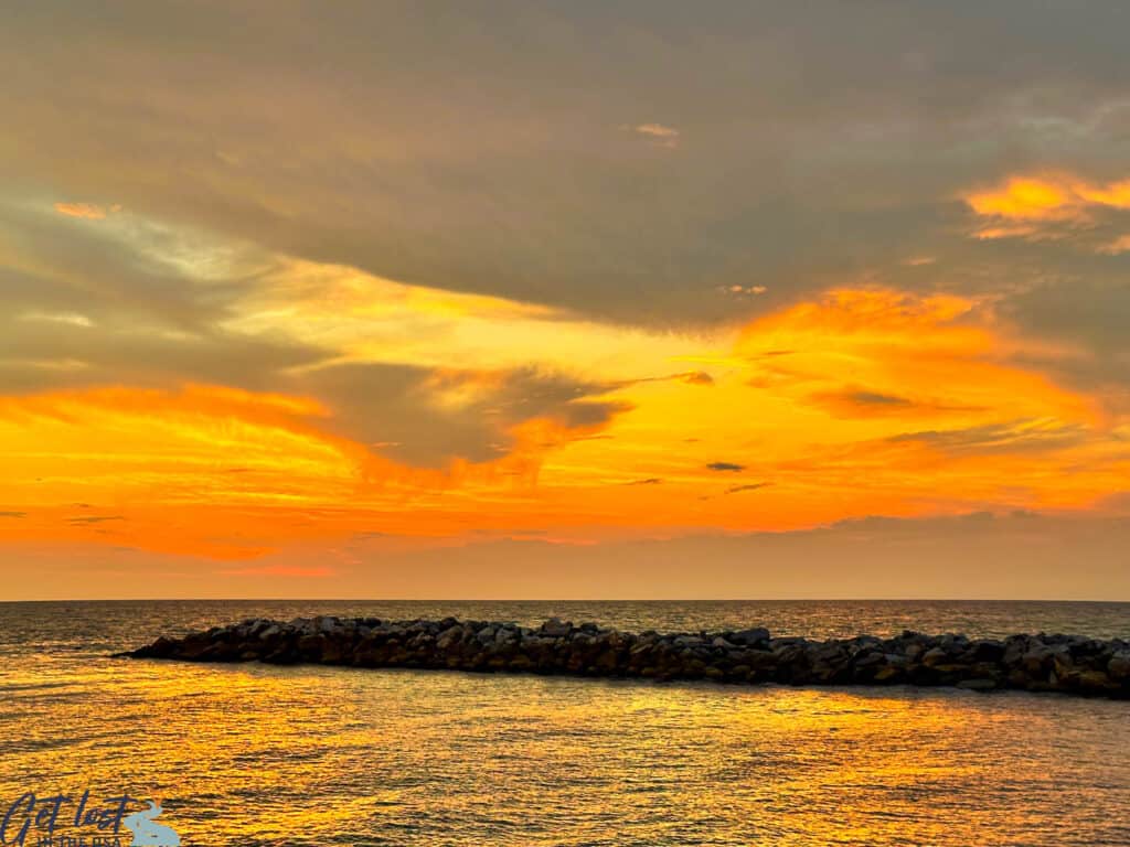 vibrant sunset afterglow with breakers in foreground.