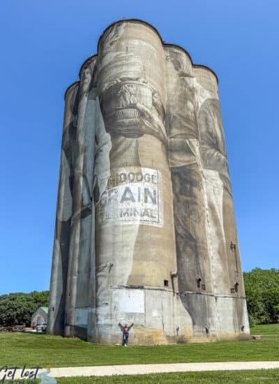 Fort Dodge IA grain silo mural with lady standing below for perspective.