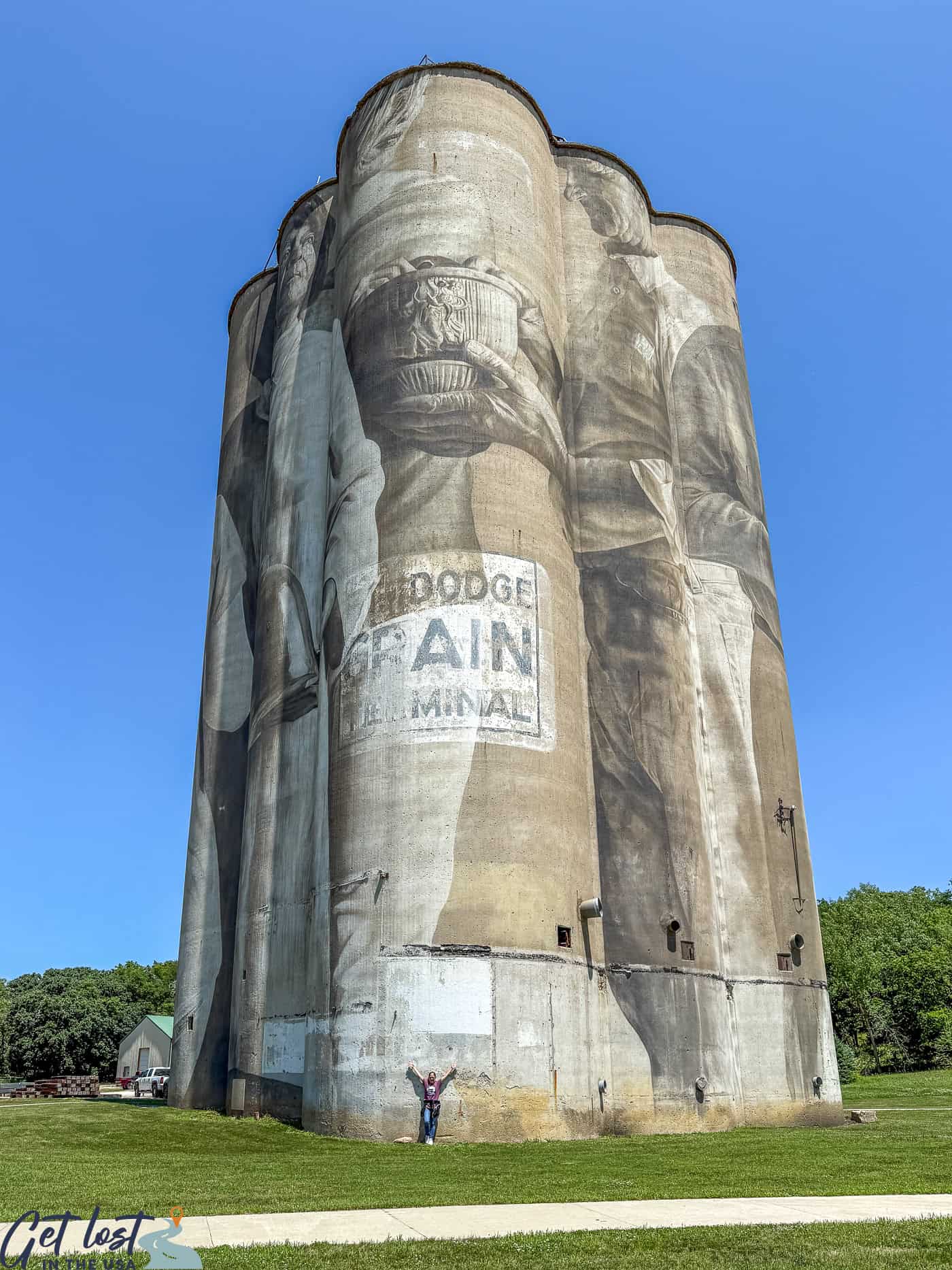 Fort Dodge IA grain silo mural with lady standing below for perspective.