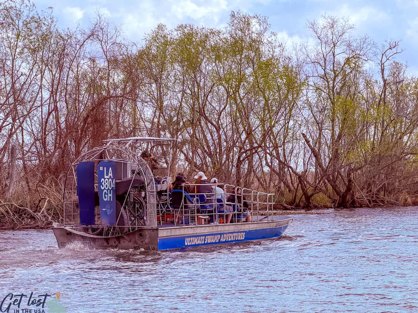 People on an airboat tour through Bayou Segnette wetlands.
