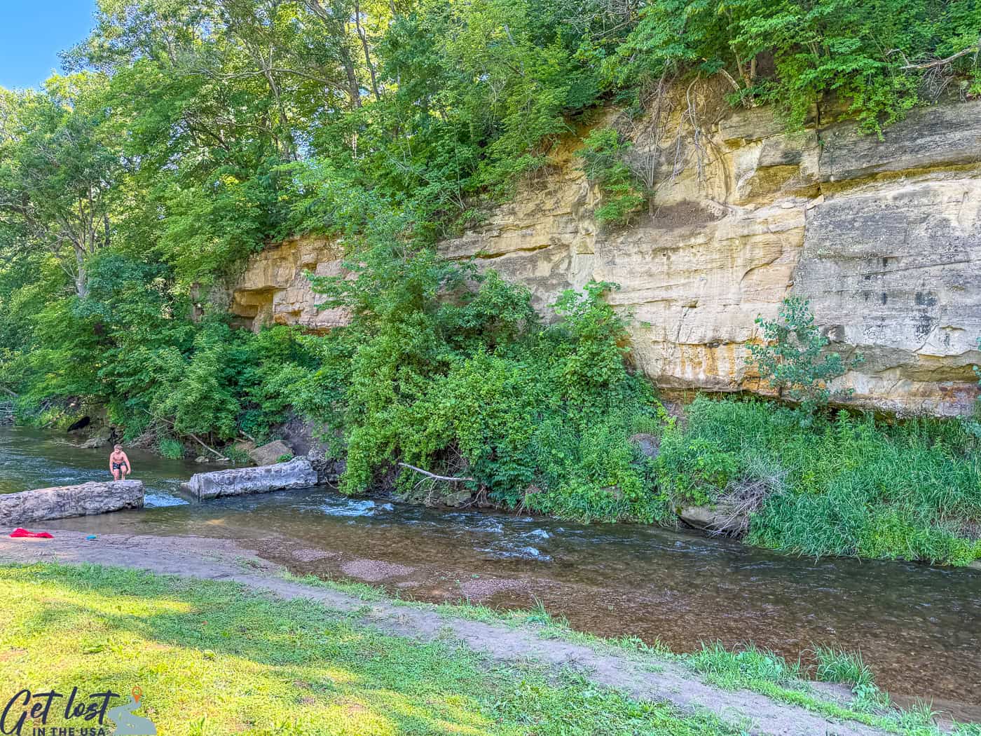 cliffs at Dolliver State Park with child playing in falls.