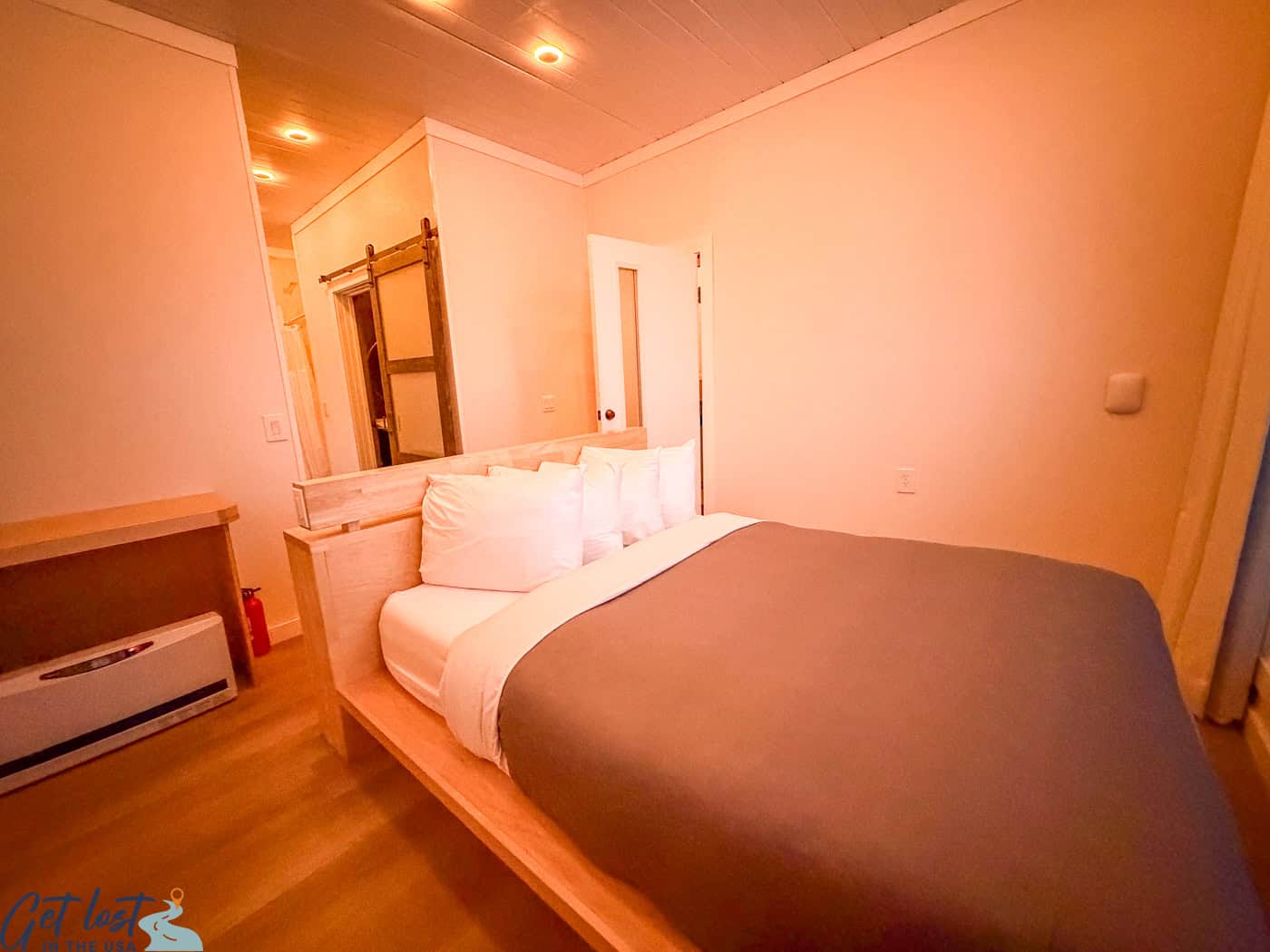 Queen bed in a Borealis Basecamp cube suite positioned to face the window for aurora viewing.