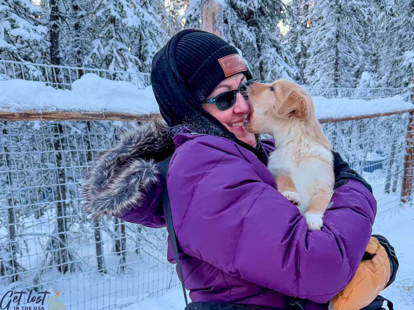 lady holding yawning puppy at Borealis Basecamp.