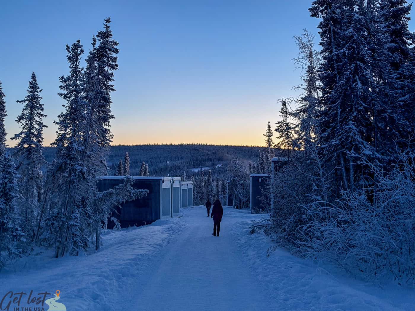 person walking on road to cubes at Borealis Basecamp.