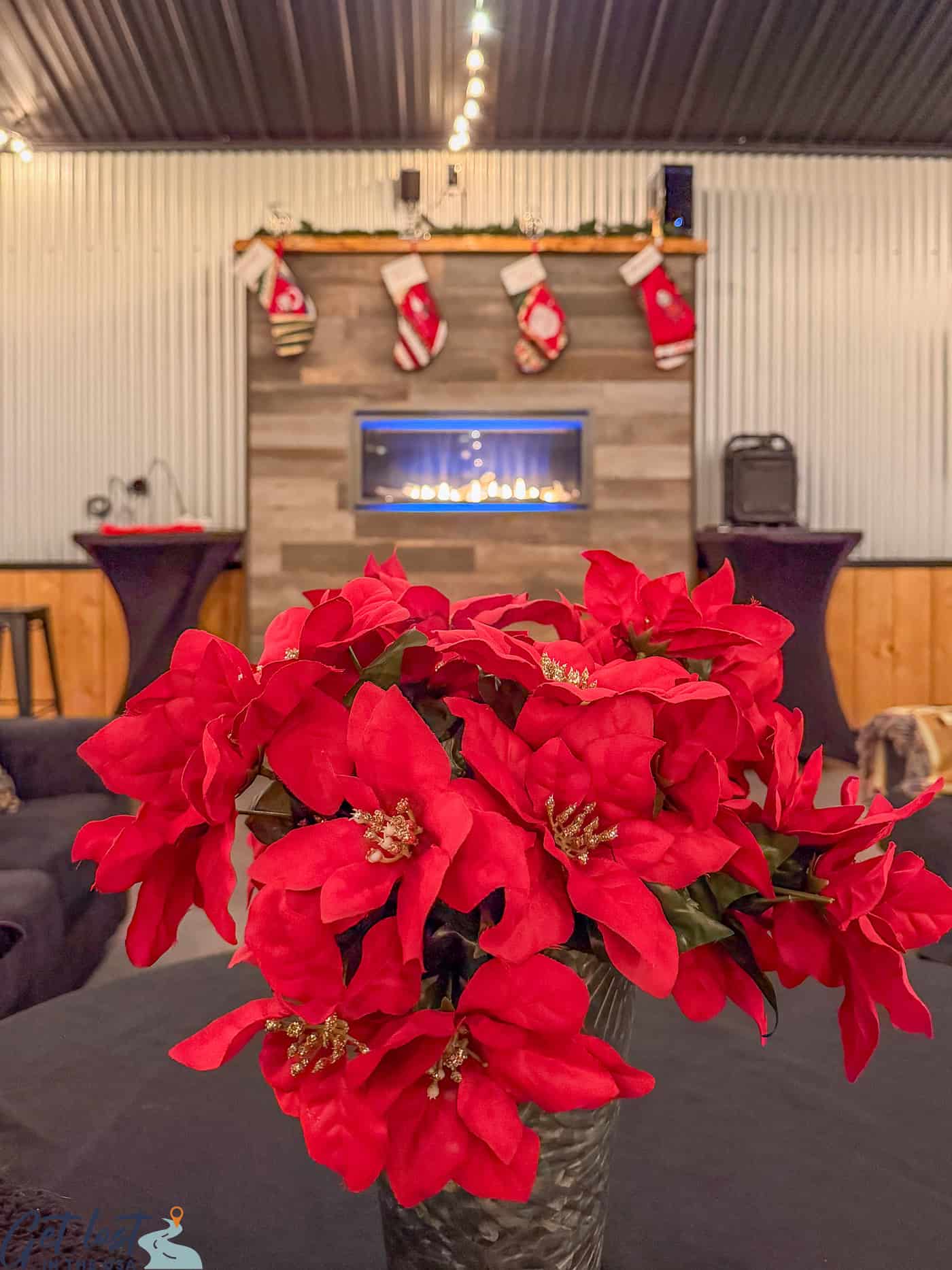poinsettia on table and virtual fireplace in background at Aurora Pointe.