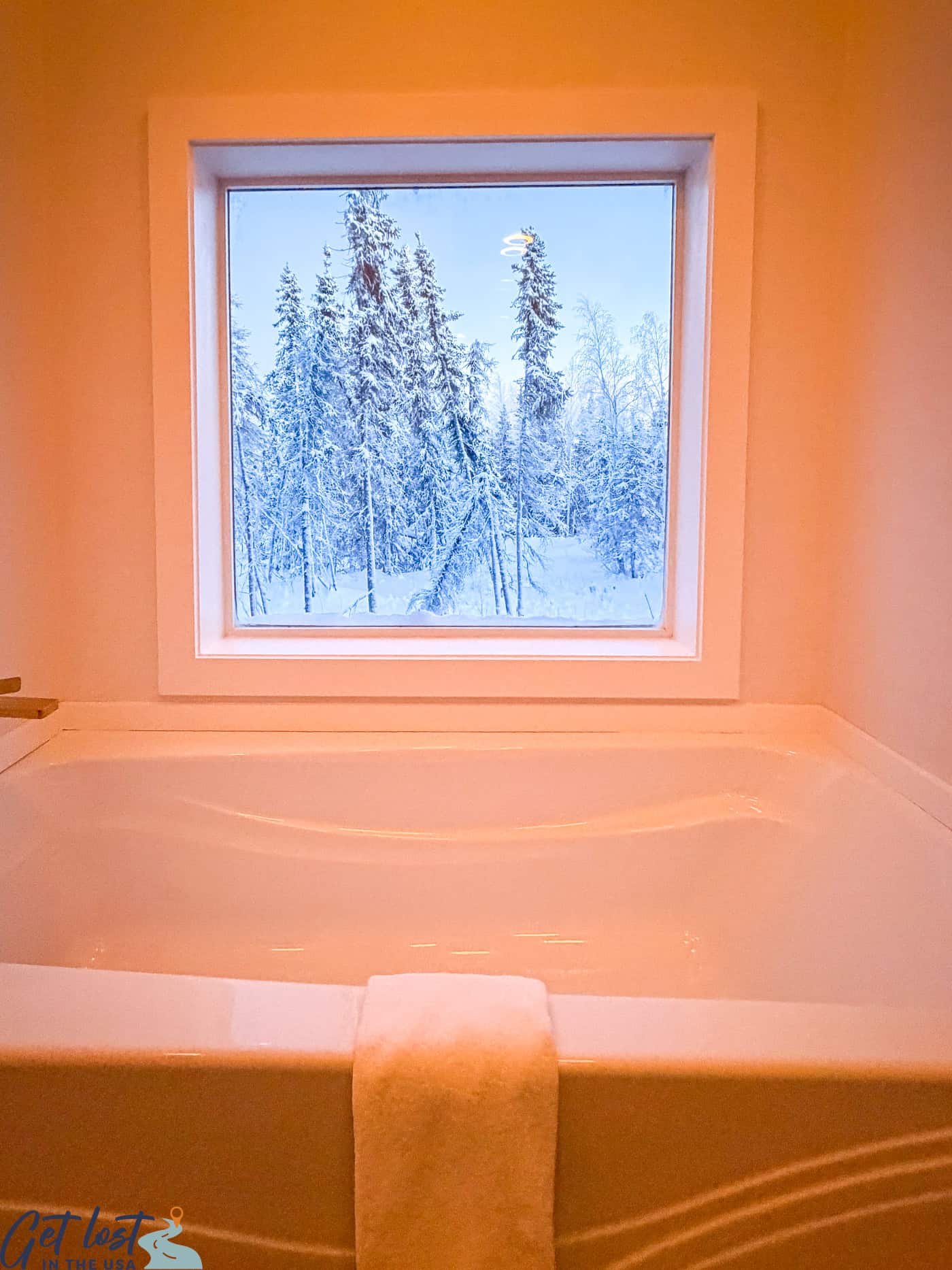 sunken tub with view of winter trees at Borealis Basecamp.