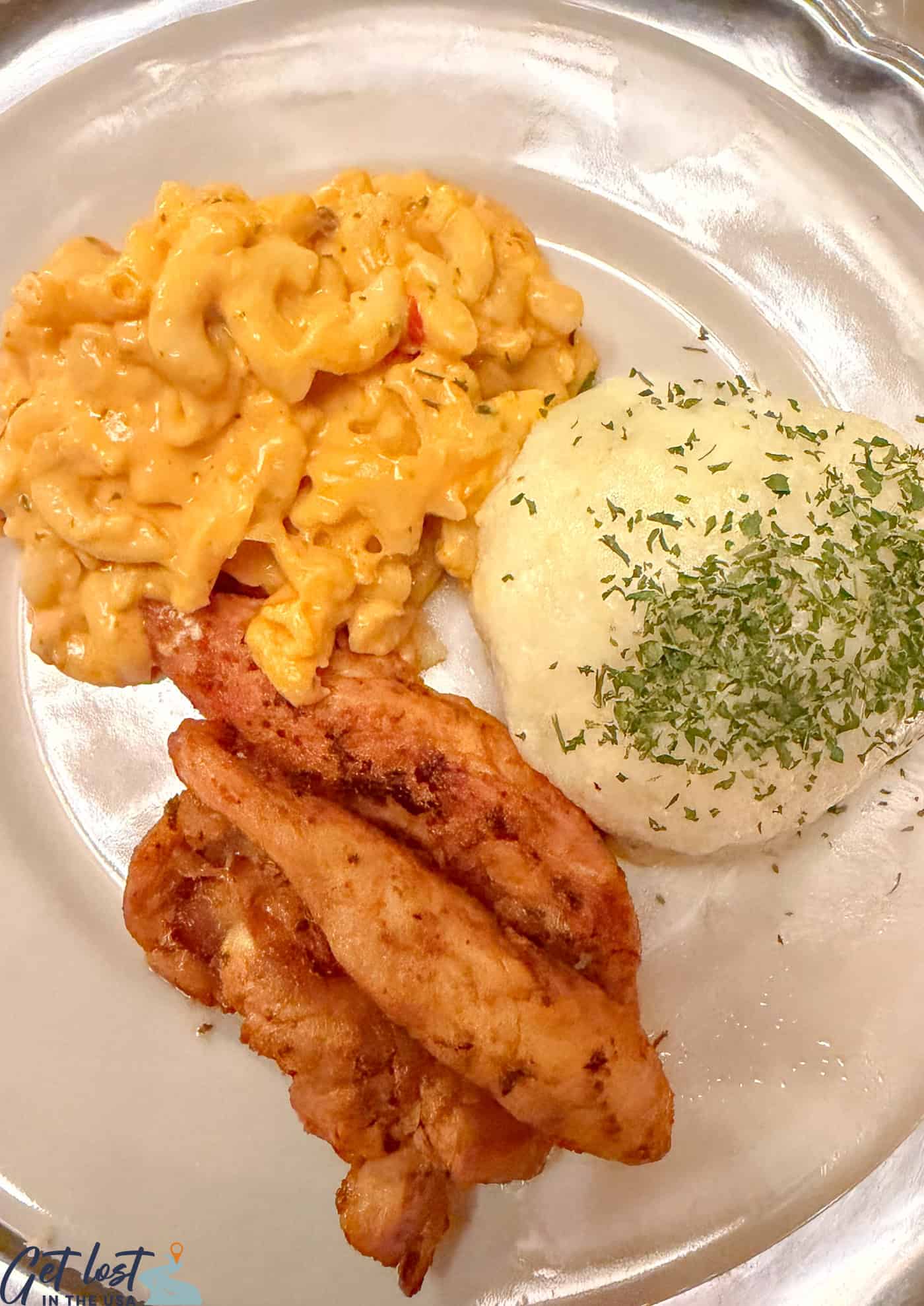 chicken, mashed potatoes and mac and cheese on plate.
