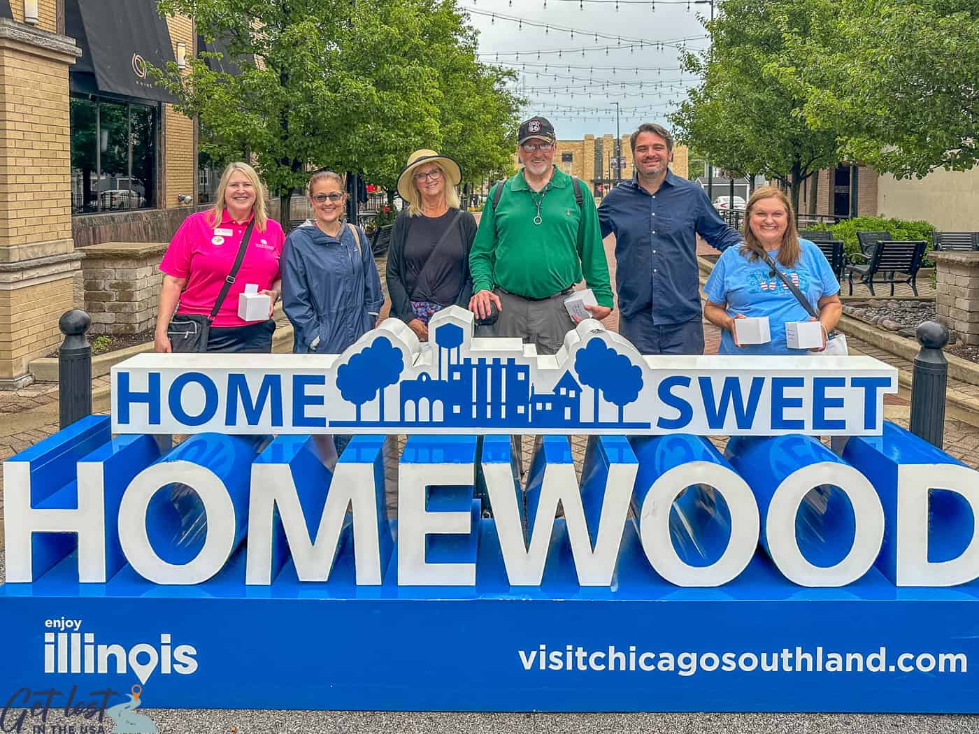 group of people by Homewood IL sign.