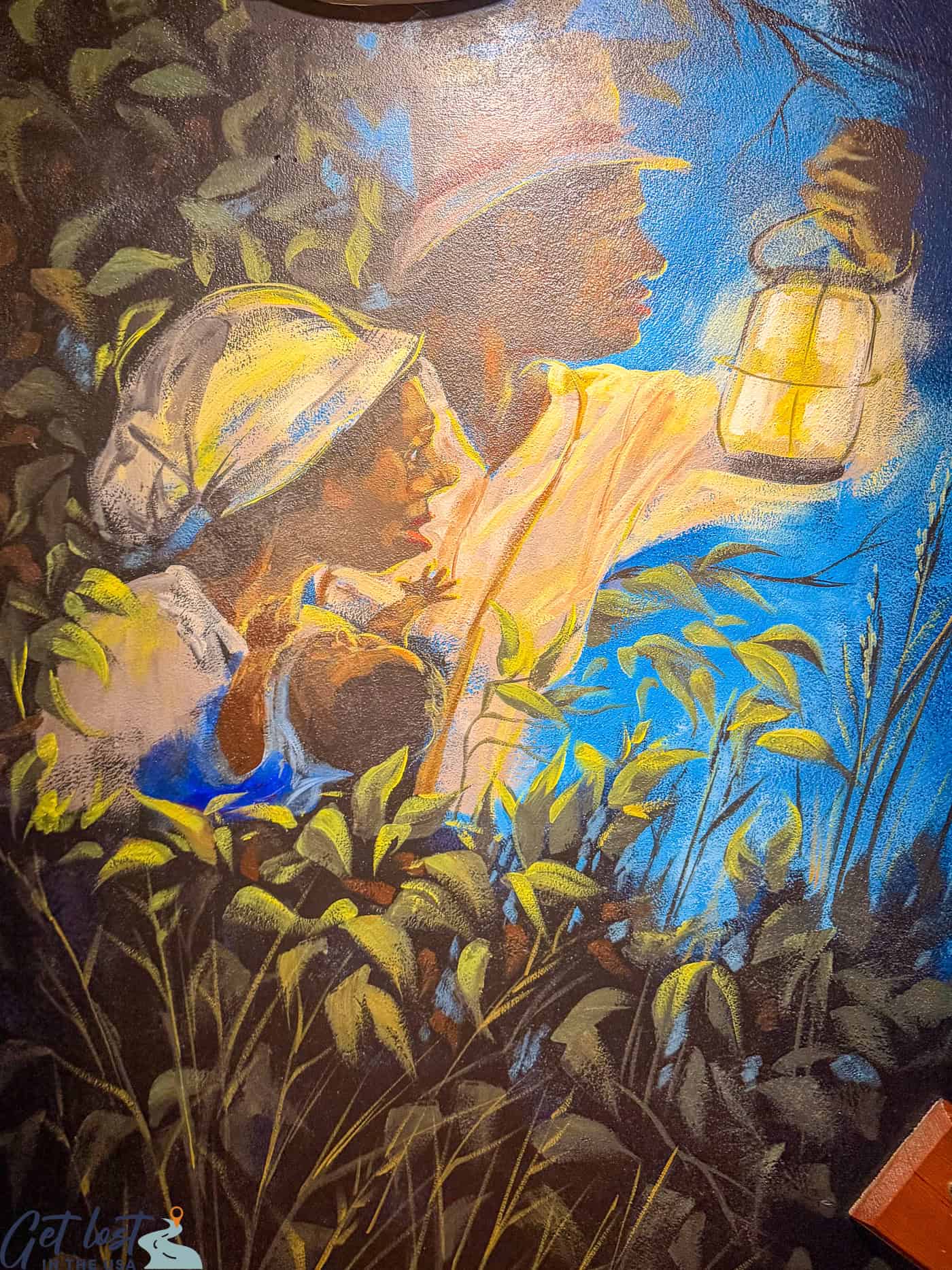 mural of freedom seekers holding lantern.