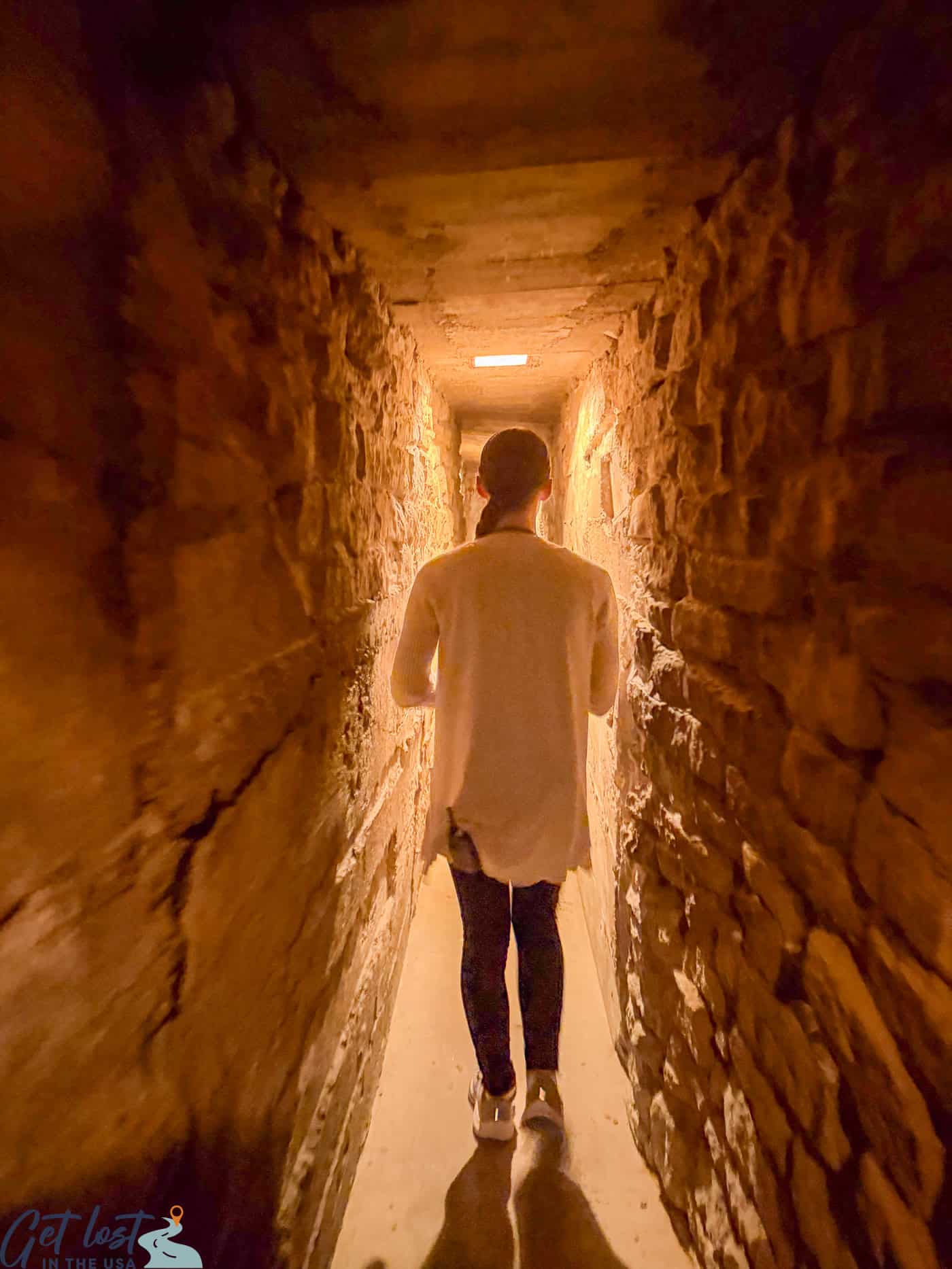 person walking through tunnel in Milton House Museum.